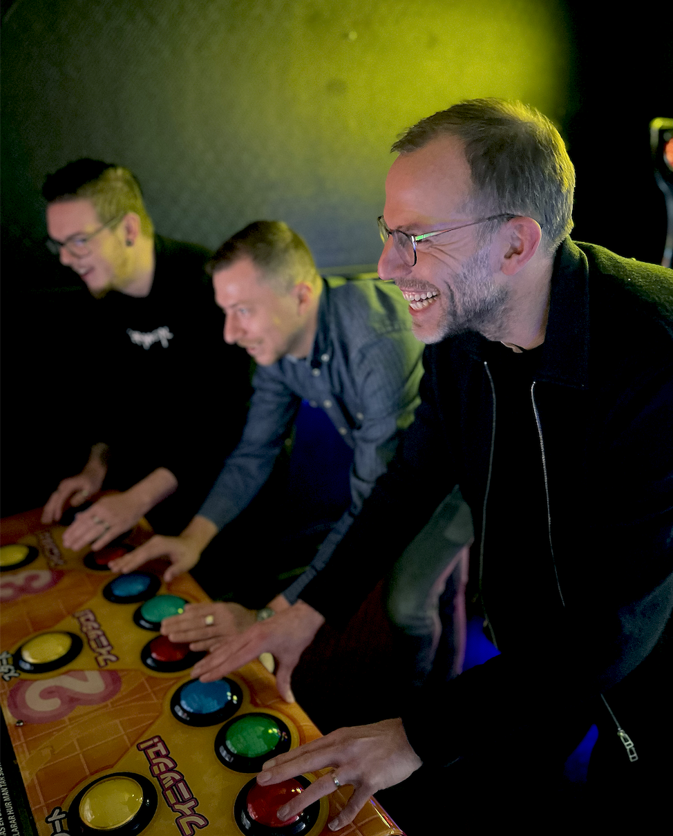 Kollegor som spelar arkadspel tillsammans